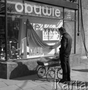 1970, Szczecin, Polska.
Ojciec z dzieckiem przed witryną sklepową udekorowaną na Święto 1 Maja.
Fot. Maciej Jasiecki, zbiory Ośrodka KARTA