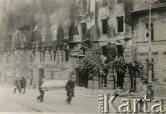 Po 1.09.1939, Warszawa, Polska.
Warszawiacy niosą trumnę obok płonącego budynku. Pl. Trzech Krzyży, na pierwszym planie po prawej stronie oficyna północna Instytutu Głuchoniemych.
Fot. NN, zbiory Ośrodka KARTA, udostępnił Roman Trojanowicz