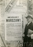 Po 1.09.1939, Warszawa, Polska.
Mężczyzna z opaską Straży Obywatelskiej przy odezwie komendanta głównego Straży Obywatelskiej Janusza Regulskiego do mieszkańców miasta.
Fot. NN, zbiory Ośrodka KARTA, udostępnił Roman Trojanowicz