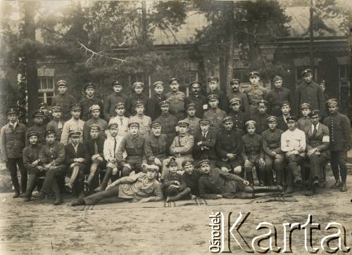 Ok. 1921, Baranowicze, woj. nowogródzkie, Polska.
Straż Etapowa Państwowego Urzędu do Spraw Powrotu Jeńców, Uchodźców i Robotników (JUR) w Baranowiczach. W 2 rzędzie, 7 z prawej, siedzi Jan Piekutowski - urzędnik państwowy, w latach 1921-1922 pełnił funkcję delegata pełnomocnego na okręg baranowicki i komisarza w Urzędzie Emigracyjnym w Baranowiczach.
Fot. NN, kolekcja Jana Piekutowskiego, zbiory Ośrodka KARTA