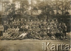Ok. 1921, Baranowicze, woj. nowogródzkie, Polska.
Straż Etapowa Państwowego Urzędu do Spraw Powrotu Jeńców, Uchodźców i Robotników (JUR) w Baranowiczach. W 2 rzędzie, 7 z prawej, siedzi Jan Piekutowski - urzędnik państwowy, w latach 1921-1922 pełnił funkcję delegata pełnomocnego na okręg baranowicki i komisarza w Urzędzie Emigracyjnym w Baranowiczach.
Fot. NN, kolekcja Jana Piekutowskiego, zbiory Ośrodka KARTA