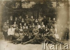 Ok. 1921, Baranowicze, woj. nowogródzkie, Polska.
Straż Etapowa Państwowego Urzędu do Spraw Powrotu Jeńców, Uchodźców i Robotników (JUR) w Baranowiczach. W 2 rzędzie, 7 z prawej, siedzi Jan Piekutowski - urzędnik państwowy, w latach 1921-1922 pełnił funkcję delegata pełnomocnego na okręg baranowicki i komisarza w Urzędzie Emigracyjnym w Baranowiczach.
Fot. NN, kolekcja Jana Piekutowskiego, zbiory Ośrodka KARTA