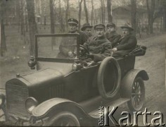1919-1928, brak miejsca.
Mężczyźni w samochodzie. W 1 rzędzie, po lewej stronie, siedzi funkcjonariusz Policji Państwowej. Z tyłu, 2 z prawej - Jan Piekutowski - urzędnik państwowy.
Fot. NN, kolekcja Jana Piekutowskiego, zbiory Ośrodka KARTA
