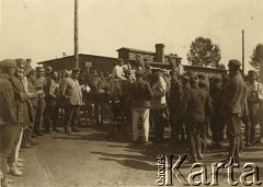 Lipiec - grudzień 1917, Szczypiorno k. Kalisza.
Żołnierze I i II Brygady Legionów, internowani w obozie jenieckim po odmowie przysięgi na wierność Niemcom. Grupa jeńców obok wozu. W prawym dolnym rogu podpis: 