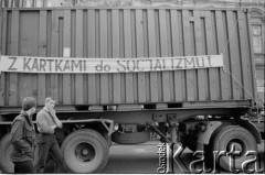 30.07.1981, Łódź, Polska.
Marsz głodowy - jeden z wielu protestów zorganizowanych w kilkunastu miastach Polski na przełomie lipca i sierpnia 1981 roku. Protesty były spowodowane problemami w zaopatrzeniu, zmniejszeniem kartkowych przydziałów mięsa oraz podwyżką cen. Marsz w Łodzi był najliczniejszy. Uczestniczyły w nim głównie kobiety z dziećmi. Na zdjęciu fragment ciężarówki z transparentem: 