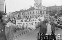30.07.1981, Łódź, Polska.
Marsz głodowy - jeden z wielu protestów zorganizowanych w kilkunastu miastach Polski na przełomie lipca i sierpnia 1981 roku. Protesty były spowodowane problemami w zaopatrzeniu, zmniejszeniem kartkowych przydziałów mięsa oraz podwyżką cen. Marsz w Łodzi był najliczniejszy. Uczestniczyły w nim głównie kobiety z dziećmi. Na zdjęciu manifestujący na Placu Wolności.
Fot. Tomasz Tomaszewski, zbiory Ośrodka KARTA