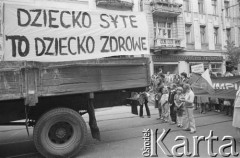 30.07.1981, Łódź, Polska.
Marsz głodowy - jeden z wielu protestów zorganizowanych w kilkunastu miastach Polski na przełomie lipca i sierpnia 1981 roku. Protesty były spowodowane problemami w zaopatrzeniu, zmniejszeniem kartkowych przydziałów mięsa oraz podwyżką cen. Marsz w Łodzi był najliczniejszy. Uczestniczyły w nim głównie kobiety z dziećmi. Na zdjęciu fragment marszu, na samochodzie ciężarowym wisi transparent: 
