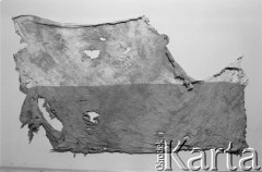 Początek grudnia 1981, Gdynia, Polska.
Flaga związana z wydarzeniami w Gdyni w dniu 17 grudnia 1970 roku. Tego dnia został zastrzelony Zbigniew Godlewski (symbol ofiar wydarzeń w grudniu 1970 roku na Wybrzeżu). Jego ciało przeniesiono na drzwiach ulicami Gdyni, w trakcie pochodu niesiona była flaga. Pochód został rozbity przez milicję. Flaga została odnaleziona i do końca PRL ukrywana w bibliotece publicznej w Gdyni. Następnie została przekazana proboszczowi parafii Najświętszego Serca Pana Jezusa w Gdyni, ksiądzu Hilaremu Jastakowi. Sztandar został oprawiony i zawisł w kościele parafialnym. Fotografia wykonana podczas przygotowania przez Małgorzatę Niezabitowską i Tomasza Tomaszewskiego materiału na ten temat do 