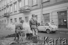 Po 13.12.1981, Warszawa, Polska.
Żołnierze przy koksowniku na ulicy Henryka Rutkowskiego (od listopada 1990 roku ulica Chmielna).
Fot. Małgorzata Niezabitowska i Tomasz Tomaszewski, zbiory Ośrodka KARTA 
