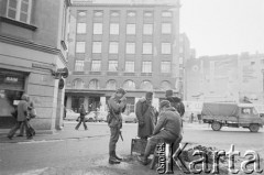 Po 13.12.1981, Warszawa, Polska.
Żołnierze przy koksowniku na ulicy Henryka Rutkowskiego (od listopada 1990 roku ulica Chmielna). W tle budynek przy ulicy Brackiej 25.
Fot. Małgorzata Niezabitowska i Tomasz Tomaszewski, zbiory Ośrodka KARTA 

