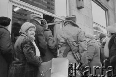 Zima 1981/1982, Warszawa, Polska.
Stan wojenny,  uzbrojony milicjant wśród osób stojących w kolejce do sklepu na ulicy Świętokrzyskiej róg Marszałkowskiej.
Fot. Małgorzata Niezabitowska i Tomasz Tomaszewski, zbiory Ośrodka KARTA