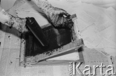 Styczeń 1982, Warszawa, Polska.
Podziemna drukarnia. Druk ulotek na ramce drukarskiej.
Fot. NN z archiwum Małgorzaty Niezabitowskiej i Tomasza Tomaszewskiego, zbiory Ośrodka KARTA
