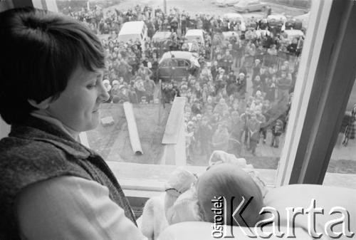 21.03.1982, Gdańsk - Zaspa, Polska.
Danuta Wałęsa w oknie swojego mieszkania prezentująca córkę Marię Wiktorię ludziom, którzy przyszli tam po chcie dziecka. Chrzest odbył się w kościele pw. Opatrzności Bożej.
Fot. Tomasz Tomaszewski, zbiory Ośrodka KARTA
