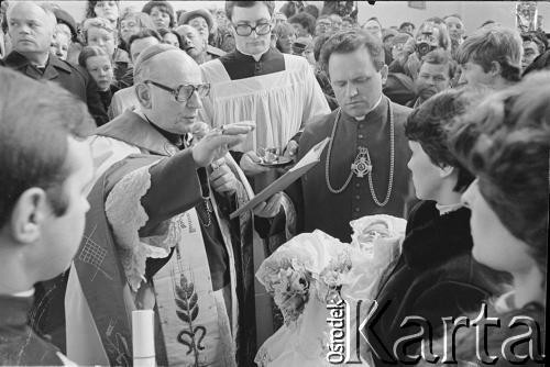 21.03.1982, Gdańsk - Zaspa, Polska.
Chrzest Marii Wiktorii Wałęsy w kościele pw. Opatrzności Bożej. Dziecko trzyma Danuta Wałęsa, chrztu udziela biskup diecezjalny gdański Lech Kaczmarek, w środku ksiądz Henryk Jankowski.
Fot. Tomasz Tomaszewski, zbiory Ośrodka KARTA
