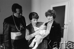 21.03.1982, Gdańsk - Zaspa, Polska.
Dzień chrztu córki Danuty i Lecha Wałęsów Marii Wiktorii. Od lewej: ksiądz Henryk Jankowski, Danuta Wałęsa z Marią Wiktorią oraz Maria Maruszczyk, matka chrzestna dziewczynki.
Fot. Tomasz Tomaszewski, zbiory Ośrodka KARTA
