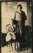 Lata 20., Comodoro Rivadavia, prowincja Chubut, Argentyna.
Marianna Koprowski (stoi) - babcia Enrique Koprowskiego - z córką. W tle mapa II Rzeczpospolitej.
Fot. NN, zbiory Enrique Koprowskiego, reprodukcje cyfrowe w Bibliotece Polskiej im. Ignacego Domeyki w Buenos Aires (Biblioteca Polaca Ignacio Domeyko) i w Ośrodku KARTA w Warszawie.