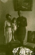 Lata 40., Rumunia.
Mężczyzna w wojskowym mundurze trzyma za rękę dziewczynkę stojącą na krześle, z lewej stoi kobieta w letniej sukience.
Fot. NN, zbiory Ośrodka KARTA