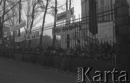 3.11.1984, Warszawa, Polska.
Pogrzeb księdza Jerzego Popiełuszki zamordowanego przez funkcjonariuszy Służby Bezpieczeństwa. Uroczystość odbyła się w kościele Świętego Stanisława Kostki na Żoliborzu, zgromadziła tysiące ludzi. Na zdjęciu  ogrodzenie kościoła, na którym zawieszono kwiaty i transparenty (na jednym z nich napisano: „Tak mało powiedziałem, nie zdążyłem. Serce moje zmęczyło się zachwytem, rozpaczą, gorliwością, nadzieją. Cz. Miłosz. Solidarność PAN”).
Fot. Maciej Czarnocki, zbiory Ośrodka KARTA.