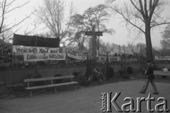 3.11.1984, Warszawa, Polska.
Pogrzeb księdza Jerzego Popiełuszki zamordowanego przez funkcjonariuszy Służby Bezpieczeństwa. Uroczystość odbyła się w kościele Świętego Stanisława Kostki na Żoliborzu, zgromadziła tysiące ludzi. Na zdjęciu  ogrodzenie kościoła, na którym zawieszono krzyż,  kwiaty i transparenty.
Fot. Maciej Czarnocki, zbiory Ośrodka KARTA.