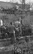 3.11.1984, Warszawa, Polska.
Pogrzeb księdza Jerzego Popiełuszki zamordowanego przez funkcjonariuszy Służby Bezpieczeństwa. Uroczystość odbyła się w kościele Świętego Stanisława Kostki na Żoliborzu, zgromadziła tysiące ludzi. Na zdjęciu  mężczyzna przed ogrodzeniem kościoła, na którym zawieszono kwiaty.
Fot. Maciej Czarnocki, zbiory Ośrodka KARTA.