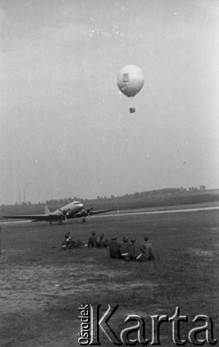 1948, Katowice, Polska.
Ogólnopolskie Zawody Modeli Latających, mężczyźni obserwujący balon Ligi Lotniczej, w tle samolot Polskich Linii Lotniczych LOT.
Fot. Kazimierz Seko, zbiory Ośrodka KARTA