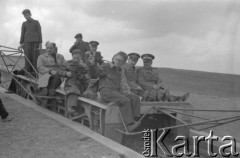 Maj lub czerwiec 1949, góra Żar, Beskid Mały, Polska.
Zawody szybowcowe - publiczność, w tym dwaj oficerowie Ludowego Wojska Polskiego i  oficer Armii Radzieckiej, siedząca na pochylni służacej szybowcom do startu.
Fot. Kazimierz Seko, zbiory Ośrodka KARTA