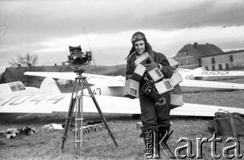 1948, Jelenia Góra, Polska.
Zawody lotnicze, pilot niosący radzieckie barografy ??-2 stosowane do dokumentacji przelotów, z lewej stoi lorneta obserwacyjna na statywie, w tle szybowce.
Fot. NN, zbiory Ośrodka KARTA, udostępniła Barbara Karwat-Seko.