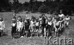 ok. 1950, Śląsk, Polska.
Grupa dzieci podczas zabawy na łące, w środku stoi chłopiec z akordeonem.
Fot. Kazimierz Seko, zbiory Ośrodka KARTA
