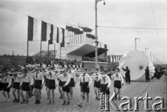 7.05.1954, Wrocław, Polska.
Defilada z okazji obchodów 10-lecia powrotu Ziem Odzyskanych do Polski. Przed trybuną honorową przechodzą chłopcy z modelami samolotów oraz członkowie Aeroklubu ze spadochronami.
Fot. Kazimierz Seko, zbiory Ośrodka KARTA