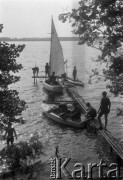 lata 60-te, Mazury, Polska.
Obóz żeglarski harcerzy z 14 Wodnej Drużyny z Olsztyna, młodzież na pomoście i w przycumowanych do niego żaglówkach.
Fot. Kazimierz Seko, zbiory Ośrodka KARTA