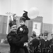 1.05.1969, Katowice, Polska.
Pochód pierwszomajowy na ulicach miasta, górnik w stroju galowym trzymający na rękach chłopca w stroju górniczym i z balonikiem w dłoni.
Fot. Kazimierz Seko, zbiory Ośrodka KARTA