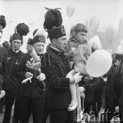 1.05.1969, Katowice, Polska.
Pochód pierwszomajowy na ulicach miasta, górnik w stroju galowym trzymający na rękach dziewczynkę z balonikiem.
Fot. Kazimierz Seko, zbiory Ośrodka KARTA