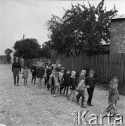 Sierpień 1970, Zagórze lub Kobyłczyce, woj. Katowice, Polska.
Klub Dziecięcy Związku Młodzieży Wiejskiej, grupa dzieci idących drogą pod opieką wychowawczyni.
Fot. Kazimierz Seko, zbiory Ośrodka KARTA
