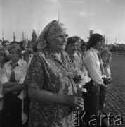 3.09.1979, Oświęcim-Brzezinka, Polska.
Manifestacja pokojowa w 40 rocznicę wybuchu II wojny światowej, na pierwszym planie starsza kobieta z bukietem kwiatów, za nią grupa dzieci i młodzieży.
Fot. Kazimiesz Seko, zbiory Ośrodka KARTA.
