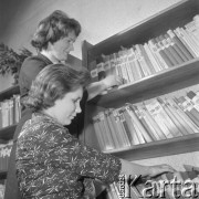 lata 60-te, Kozłowa Góra k/Piekar Śląskich, Polska.
Dom Ludowy pod patronatem Związku Młodzieży Wiejskiej, dziewczyny wypożyczające książki z biblioteki. 
Fot. Kazimierz Seko, zbiory Ośrodka KARTA.