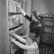 lata 60-te, Kozłowa Góra k/Piekar Śląskich, Polska.
Dom Ludowy pod patronatem Związku Młodzieży Wiejskiej, dziewczyny wypożyczające książki z biblioteki. 
Fot. Kazimierz Seko, zbiory Ośrodka KARTA.