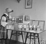 lata 60-te, Kozłowa Góra k/Piekar Śląskich, Polska.
Członkini Zespołu Pieśni i Tańca ZMW Kozłowa Góra, obok stołu z nagrodami i dyplomami dla czołowych działaczy.
Fot. Kazimierz Seko, zbiory Ośrodka KARTA.