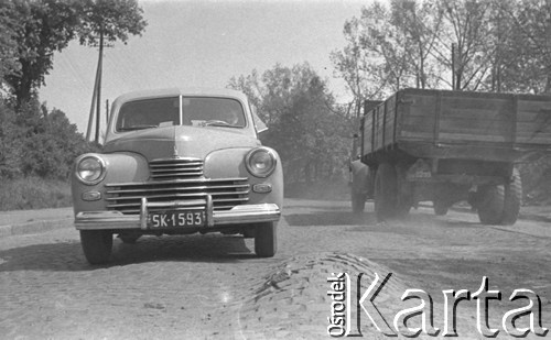 lata 60-te, woj. Katowice, Polska.
Samochód osobowy i ciężarówka na wyboistej drodze.
Fot. Kazimierz Seko, zbiory Ośrodka KARTA