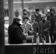 Październik 1970, Warszawa, Polska.
 Uliczny handlarz oferujący zabawki wykonane z kapsli od butelek.
 Fot. Jarosław Tarań, zbiory Ośrodka KARTA [70-1]
   
