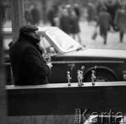 Październik 1970, Warszawa, Polska.
 Uliczny handlarz oferujący zabawki wykonane z kapsli od butelek.
 Fot. Jarosław Tarań, zbiory Ośrodka KARTA [70-1]
   
