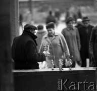 Październik 1970, Warszawa, Polska.
 Uliczny handlarz oferujący zabawki wykonane z kapsli od butelek.
 Fot. Jarosław Tarań, zbiory Ośrodka KARTA [70-1]
   
