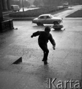 4.06.1970, Warszawa, Polska.
 Ulewa, chłopiec chroniący się przed deszczem.
 Fot. Jarosław Tarań, zbiory Ośrodka KARTA [70-48]
   
