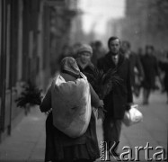 Październik 1970, Warszawa, Polska.
 Wiejska kobieta sprzedająca świerkowe gałązki  i suche kwiaty na ulicy.
 Fot. Jarosław Tarań, zbiory Ośrodka KARTA [70-91]
   
