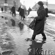 Marzec 1970, Warszawa, Polska.
Aleje Jerozolimskie przy Marszałkowskiej, kobieta przechodząca przez zalane tory tramwajowe.
Fot. Jarosław Tarań, zbiory Ośrodka KARTA [70-184]
 
