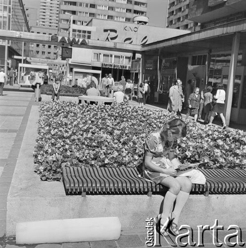 27.08.1973, Warszawa, Polska.
 Pasaż za Domami Centrum, dziewczyna czytająca gazetę, w tle kino 