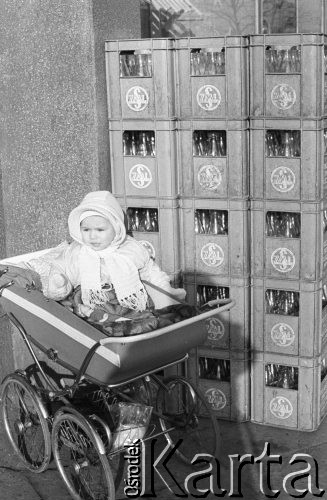 6.04.1975, Warszawa, Polska.
Dziecko w wózku, w tle skrzynki z pustymi butelkami na mleko.
Fot. Jarosław Tarań, zbiory Ośrodka KARTA [75-231]
 
