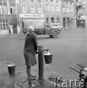 Listopad 1977, Golub-Dobrzyń, Polska
Fragment Rynku, kobieta z wiadrem przy pompie.
Fot. Jarosław Tarań, zbiory Ośrodka KARTA [77-29]

