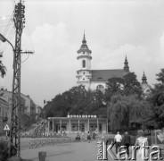 Lipiec 1977, Ostrowiec Świętokrzyski, Polska
Fragment miasta, kościól pod wezwaniem św. Michała Archanioła, na pierwszym planie sklep sportowy, z lewej napis: 