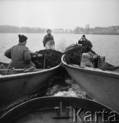 20-21.11.1979, Ostróda, woj. olsztyńskie, Polska.
Rybacy Zespołu Ostróda w łodziach rybackich. W oddali widoczny jest zarys drzew i domów na drugim brzegu jeziora.
Fot. Jarosław Tarań, zbiory Ośrodka KARTA [79-19] 
