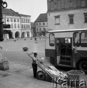 23.08.1979, Tarnów, Polska.
Mężczyzna z wózkiem i paczką oraz fragment autobusu. Na drugim planie widoczny jest rynek miasta. 
Fot. Jarosław Tarań, zbiory Ośrodka KARTA [79-9] 
